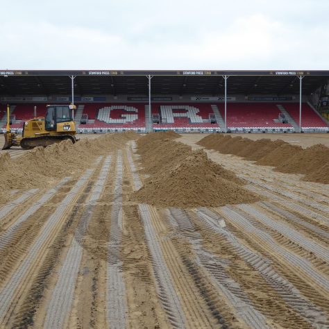 The bulldozer temporarily parked ready to spread the sand across the whole area of the pitch.