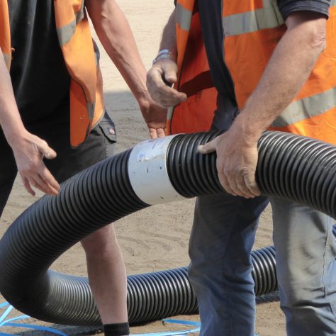Two coils of 150mm diameter pipe being joined by a plastic collar. 