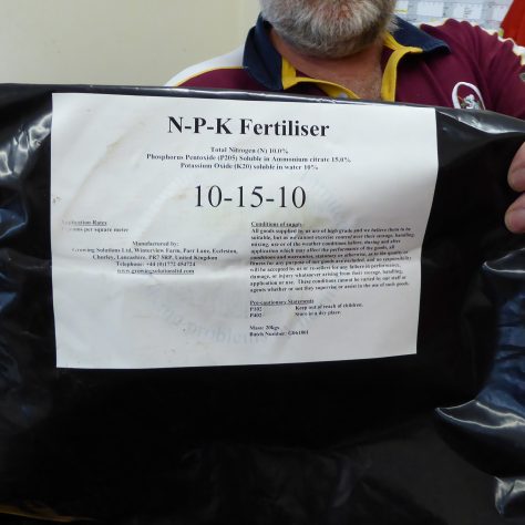 At 7am fertilizer was spread across the pitch.  Dave Balmer holds up the label showing the balance of the components.