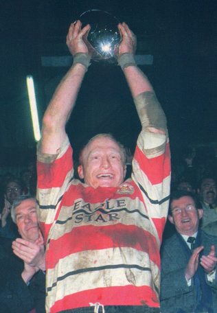 Peter Glanville holds the C & G trophy aloft